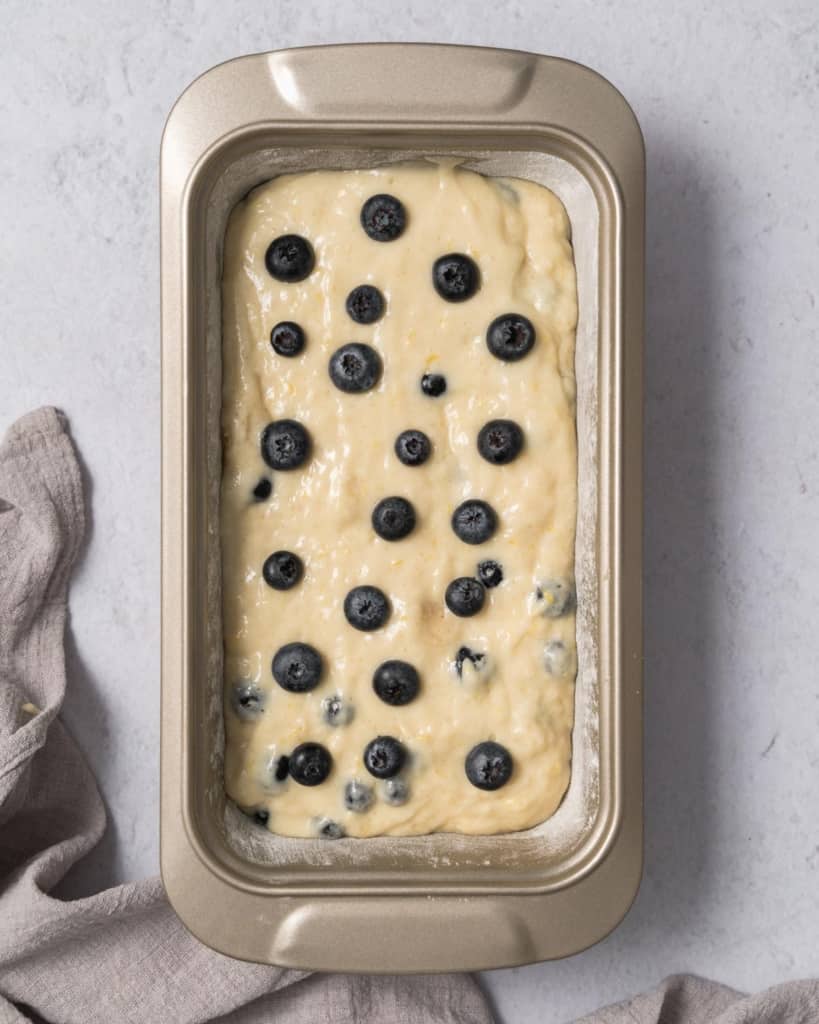batter placed in pan topped with blueberries 