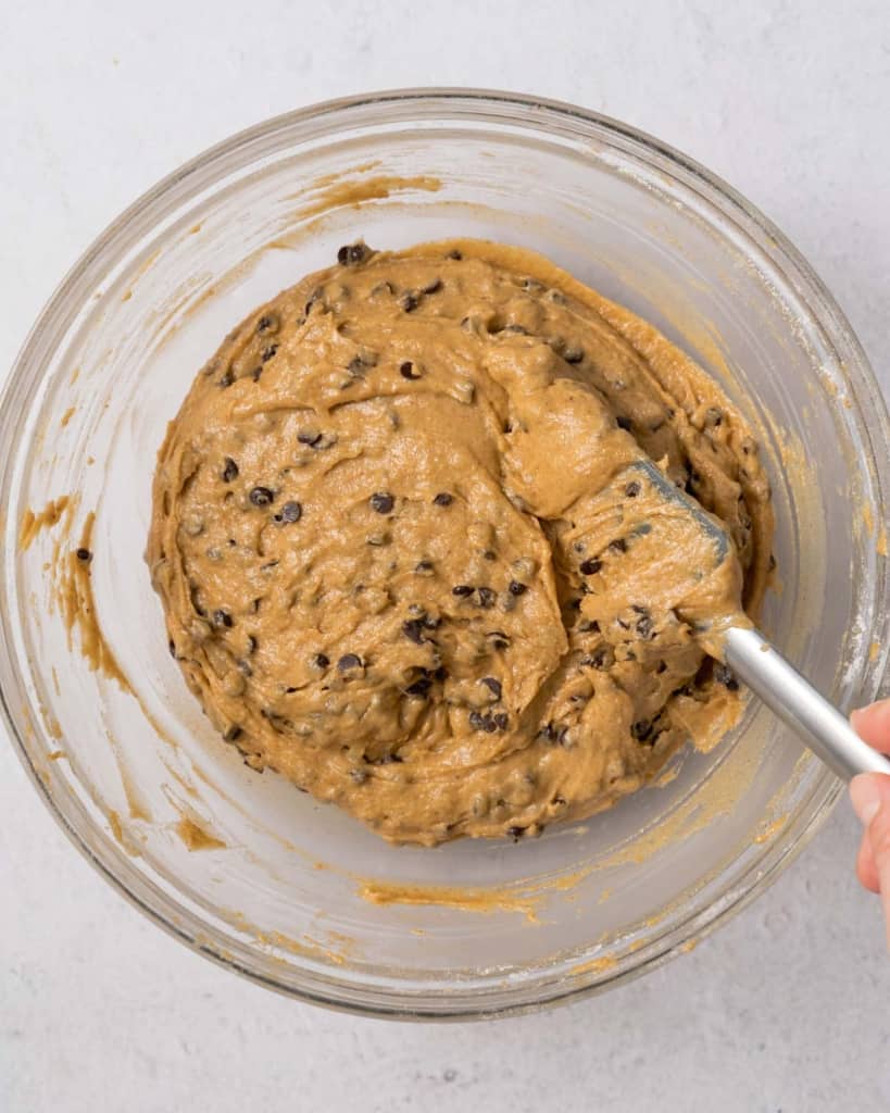 spatula in a bowl of chocolate chip cookie dough mix 