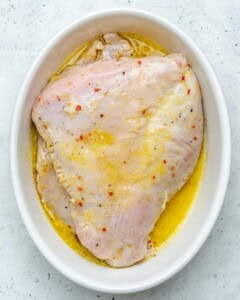 Marinated turkey breast in a dish.