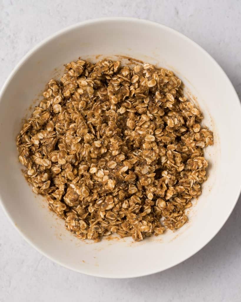 Oat mixture combined with peanut butter mixture in a bowl.