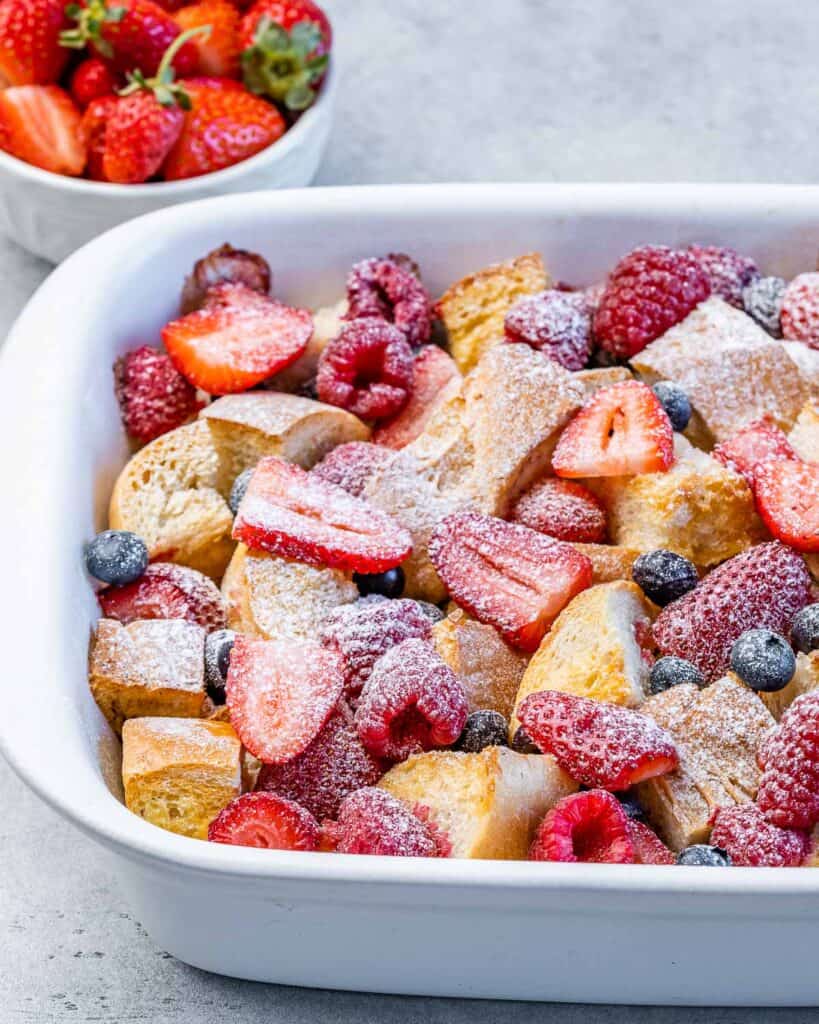French toast casserole topped with berries and powdered sugar.
