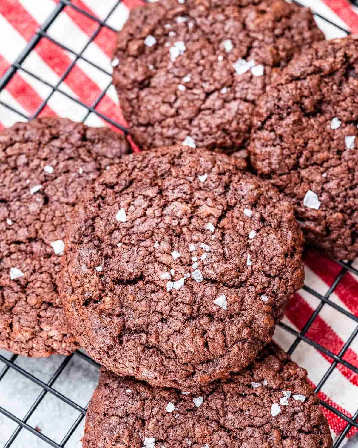 Chocolate cookies on a wire rack cooling off.