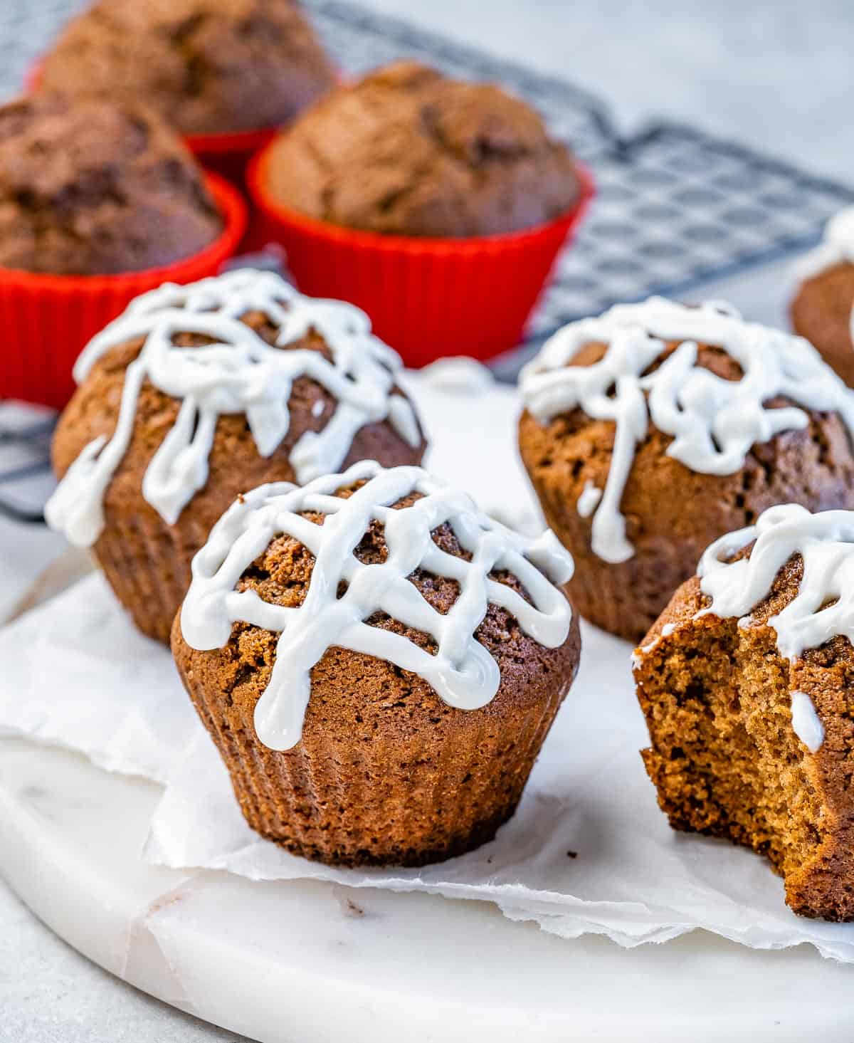 Gingerbread muffins topped with glaze on a a marble tray.