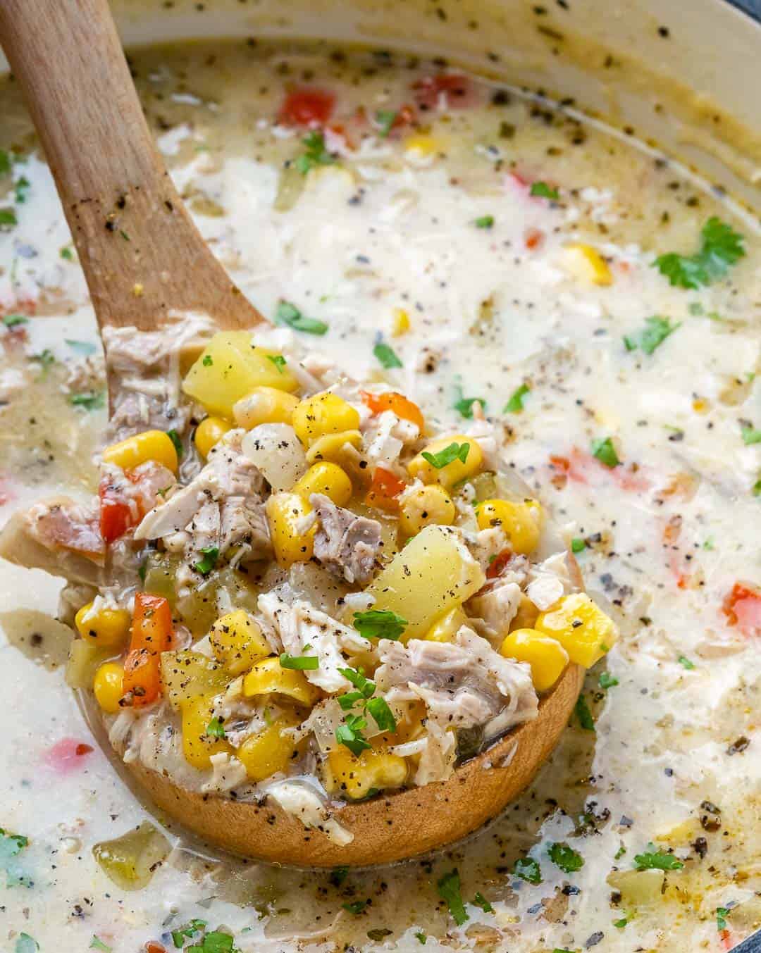 spoon scooping chicken corn chowder out of the pot.