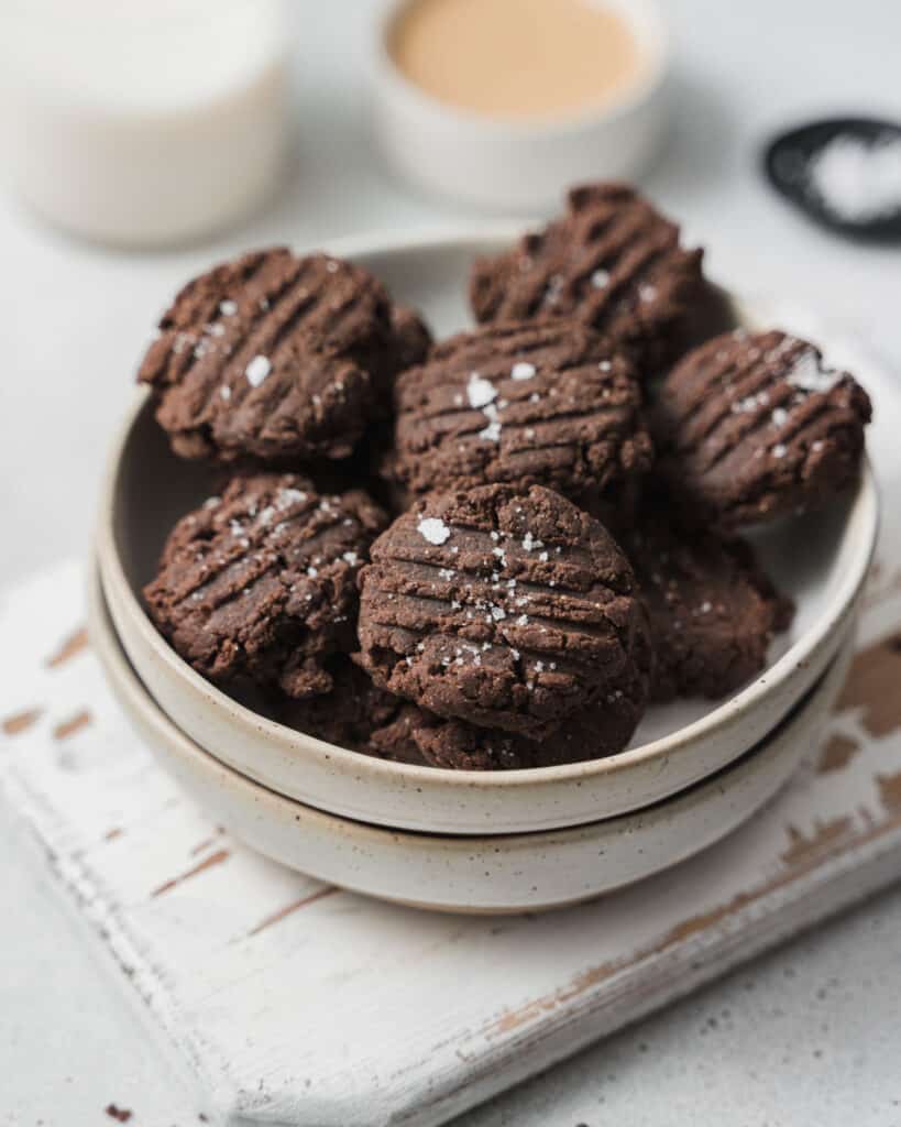 chocolate cookies over two plates stacks over a cutting board