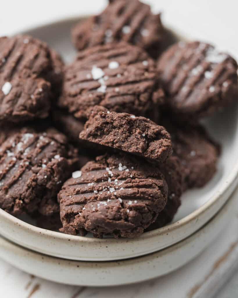 Chocolate peanut butter cookies on a plate with one bite into.