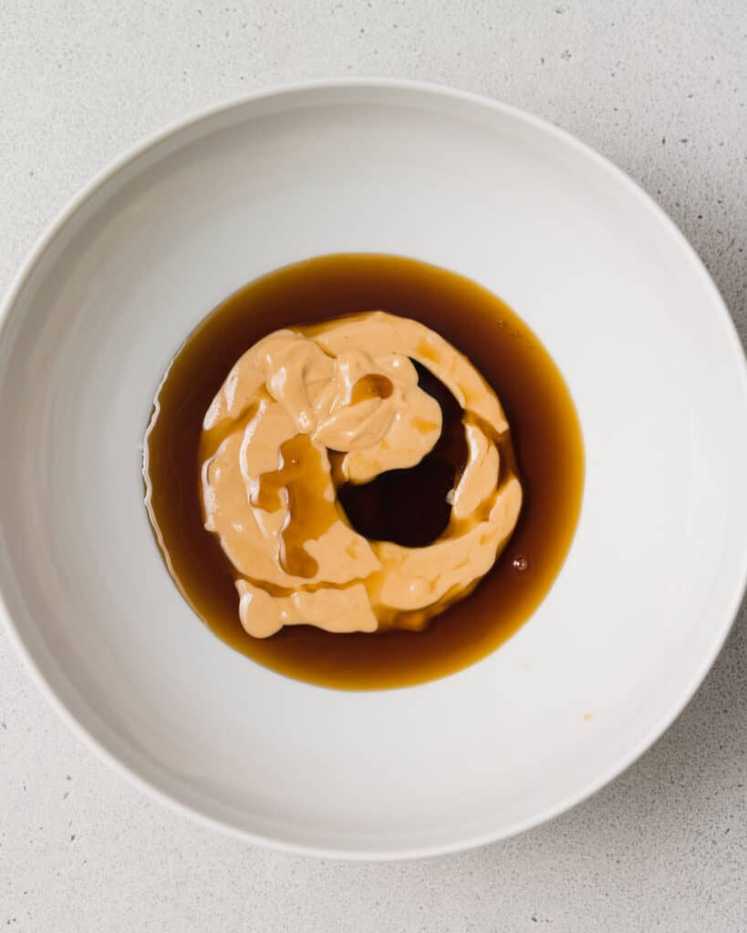 maple syrup added over peanut butter in a round plate
