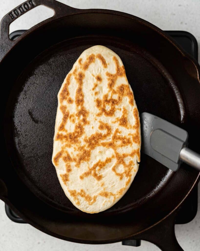 Flipping naan bread in a skillet.