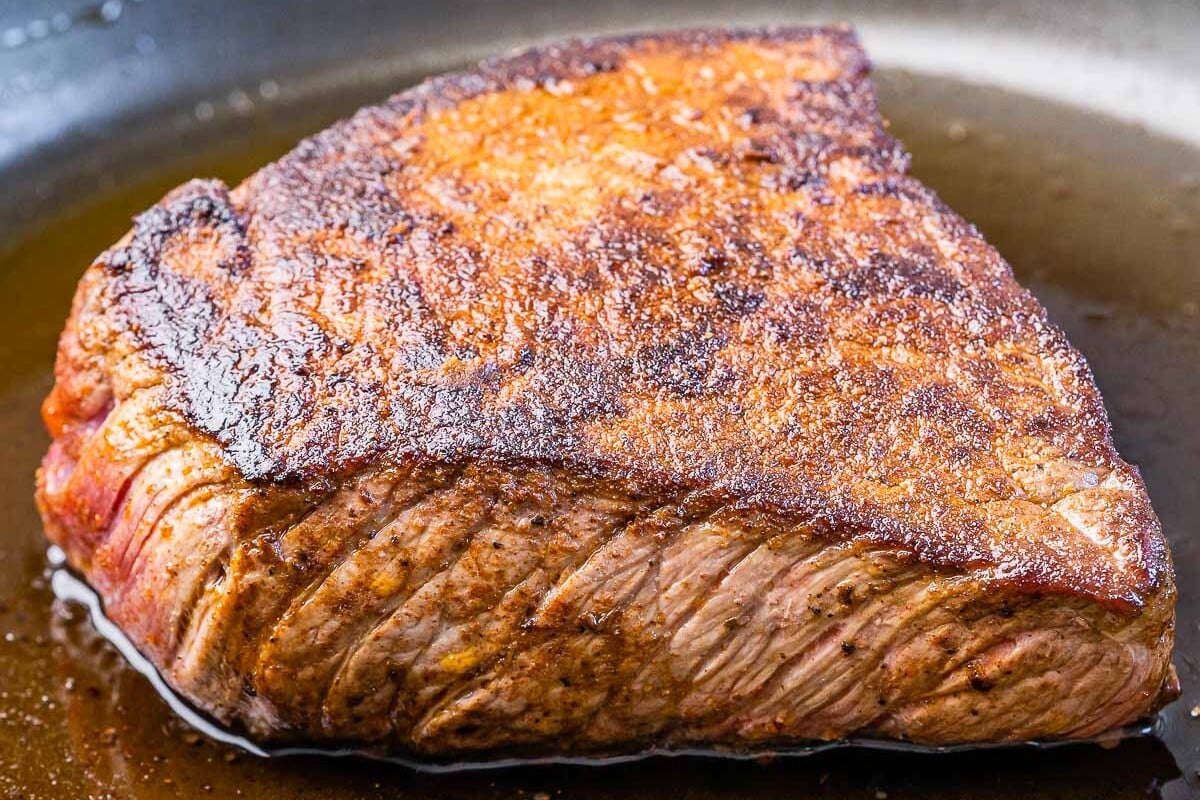seared rump roast in a skillet.