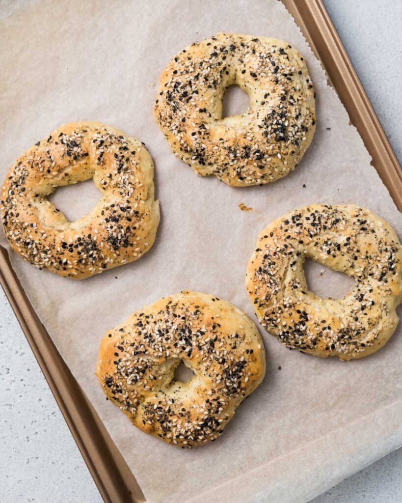 4 baked bagels on a sheet pan 