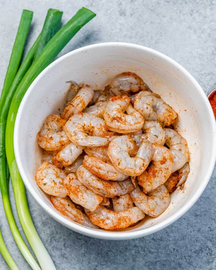 seasoned raw shrimp in a round white bowl