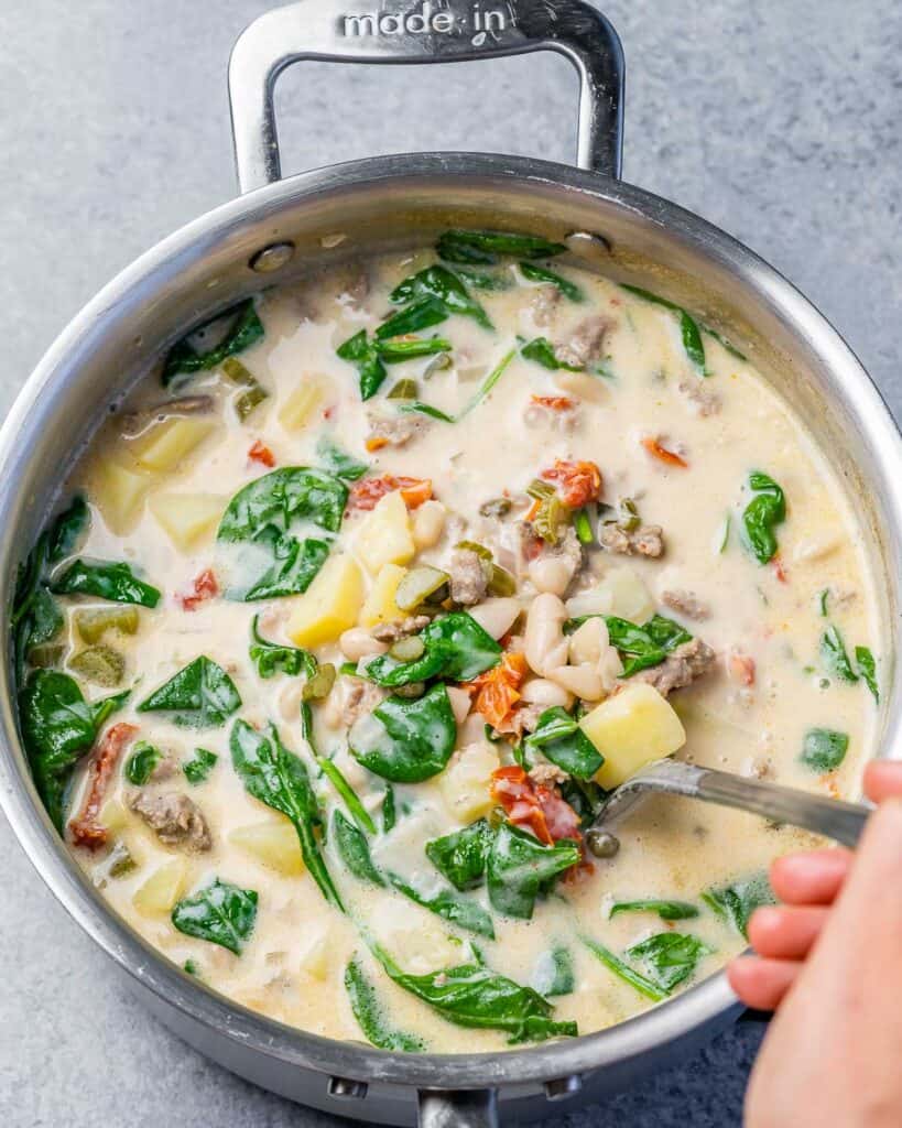 Tuscan white bean soup with potatoes, Italian sausage and spinach in a large pot.