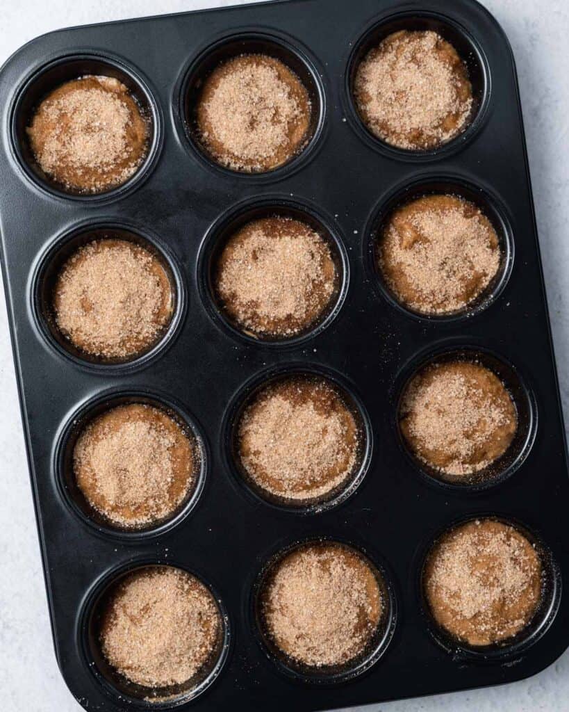 Muffin batter in a muffin tin.