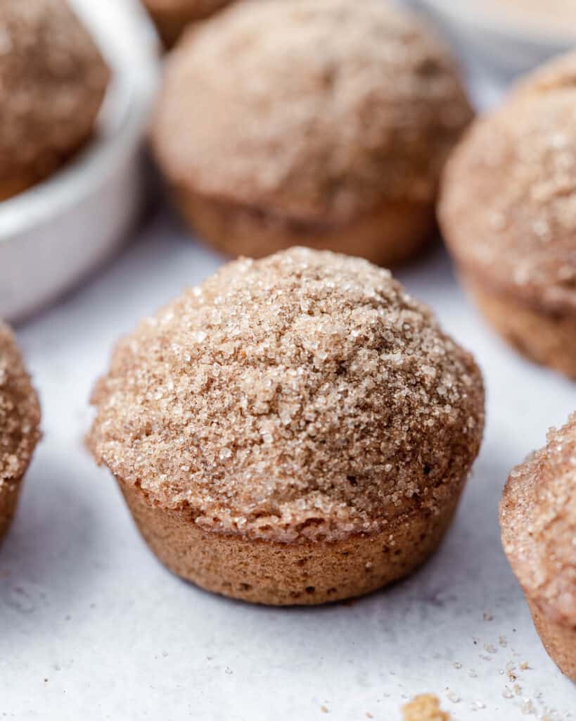 side shot of cinnamon muffins on a flat white surface 