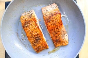 cooked salmon filets in a pan.
