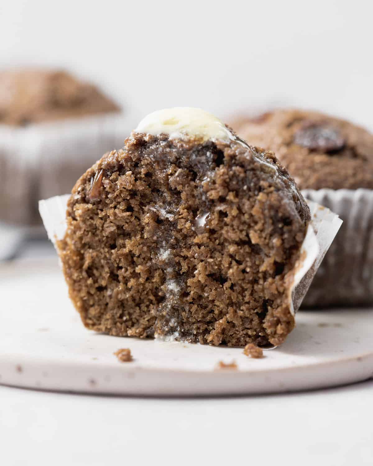 Bran muffin cut in half with melted butter dripping down.