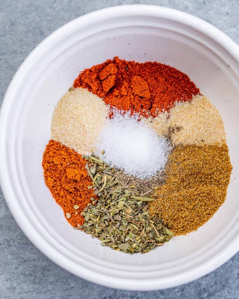 Mixing spices in a small white bowl.