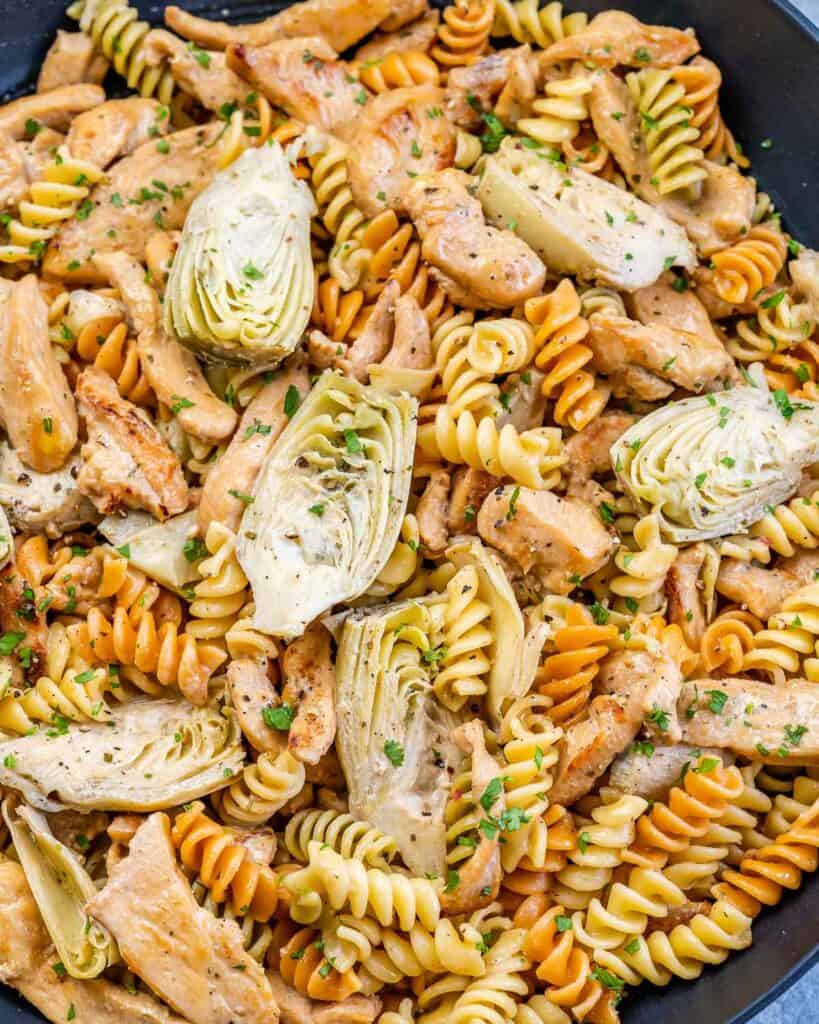 top close up view of pasta dish with chicken and artichoke hearts
