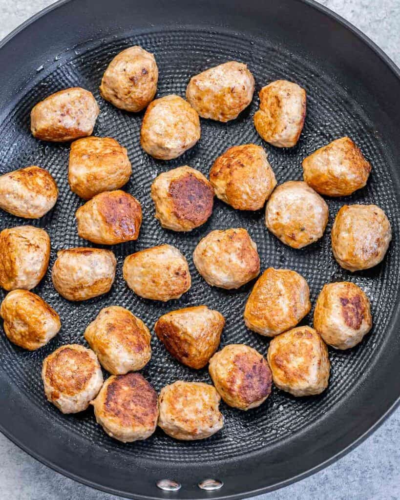 Searing meatballs in a pan.