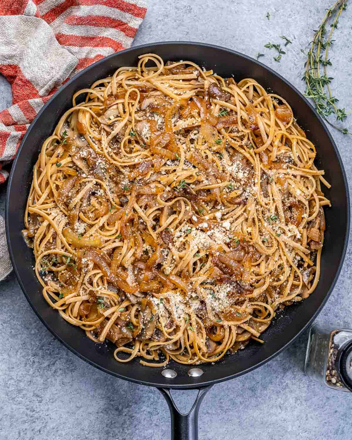Black skillet with French onion pasta.