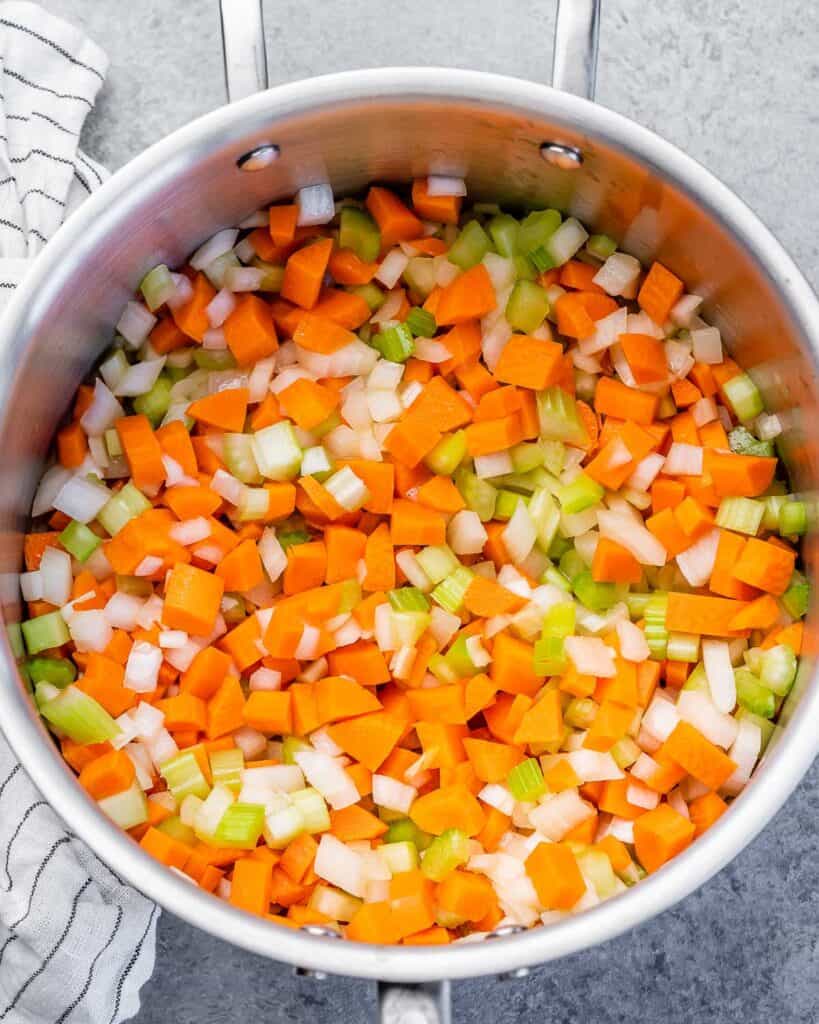 Carrots, onion and celery sautéing in a large pot.