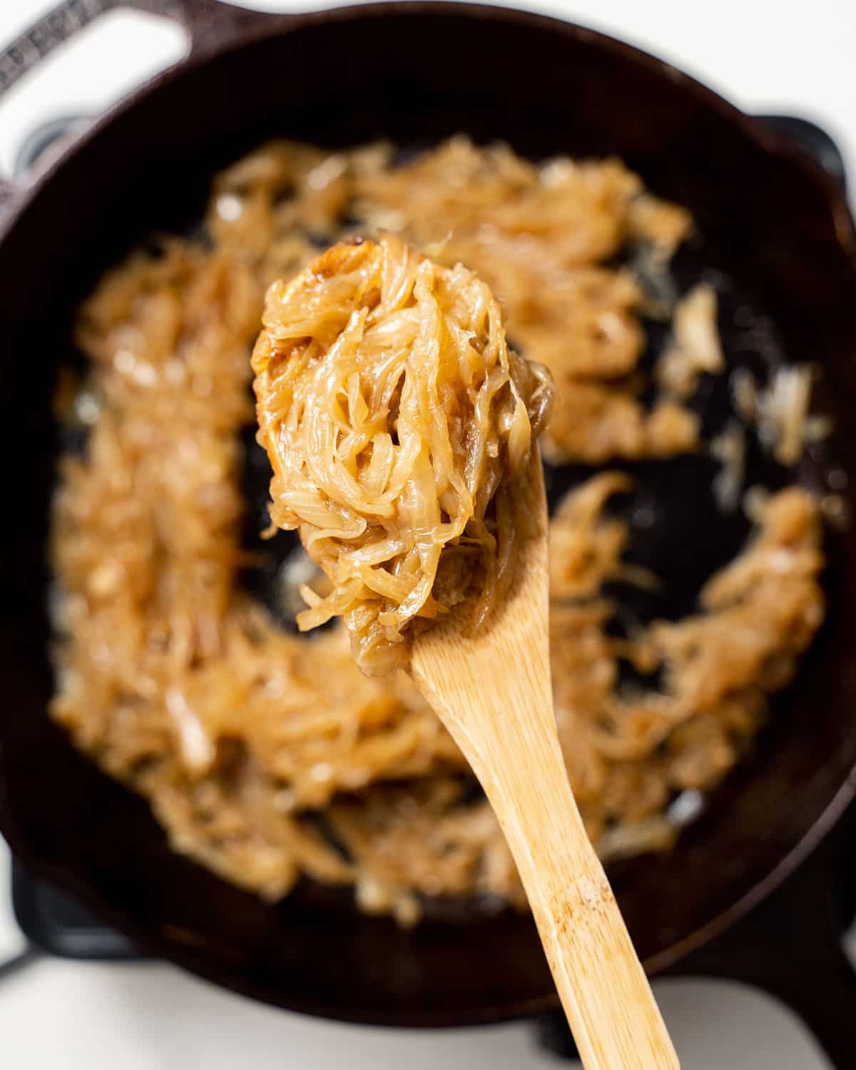 wooden spoon holding some caramelized onions