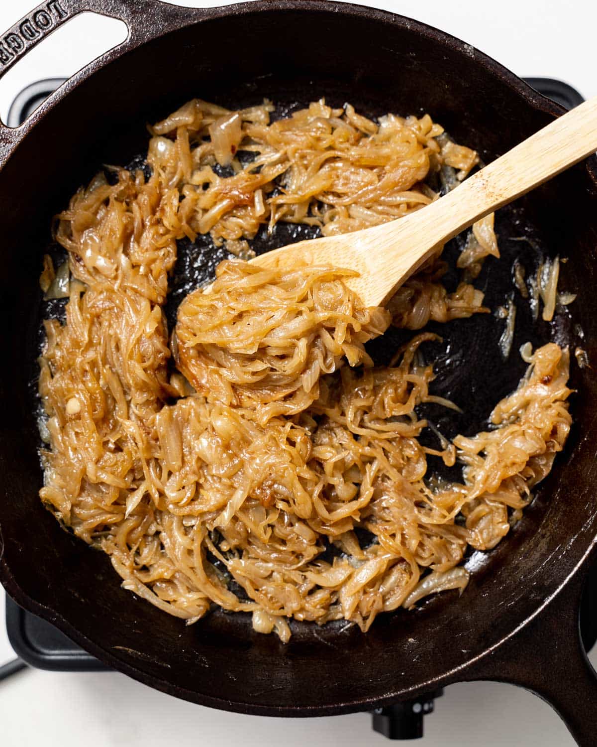 caramelized onions being mixed in a black skillet