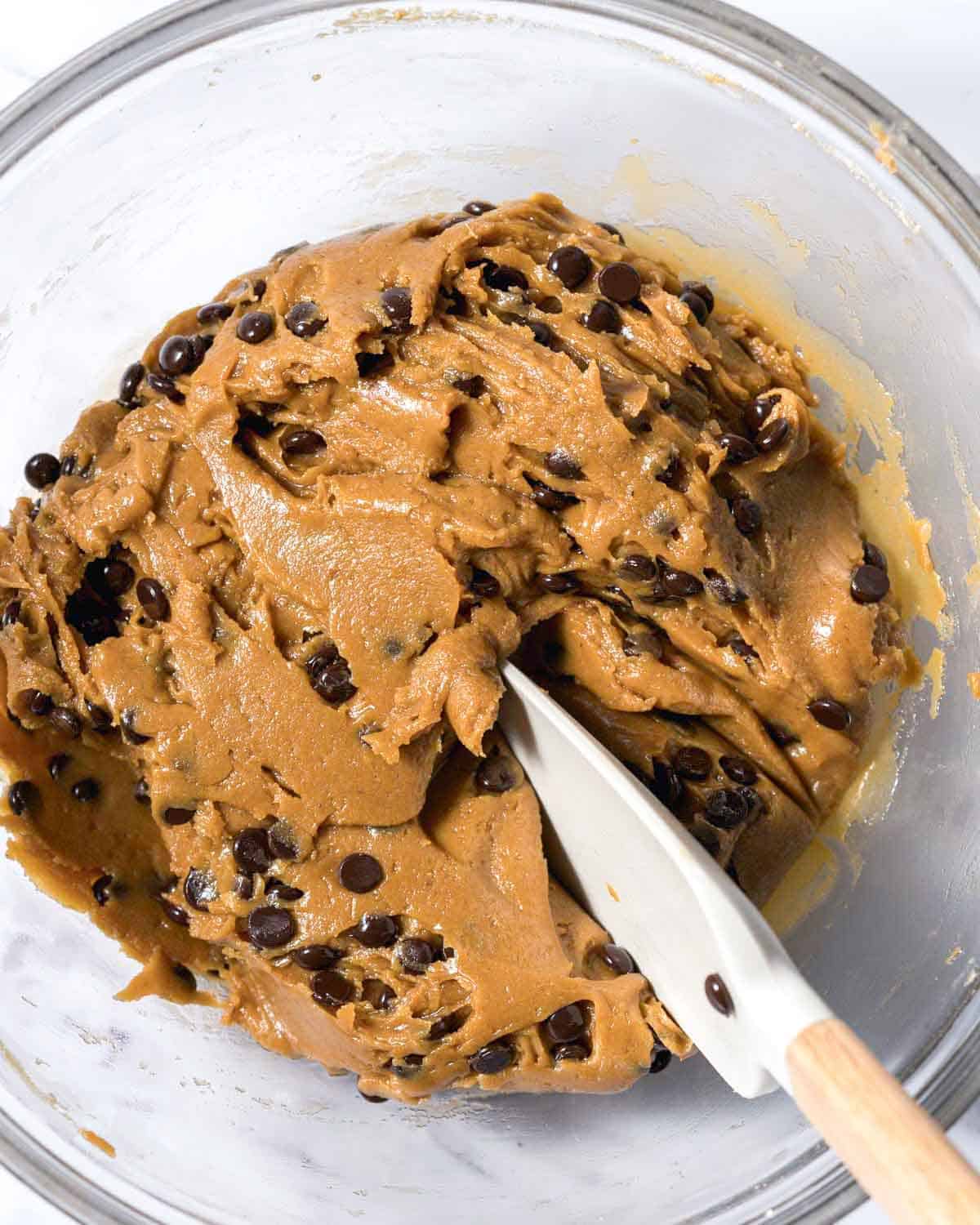 spatula in the chocolate chip cookie dowl in a bowl.