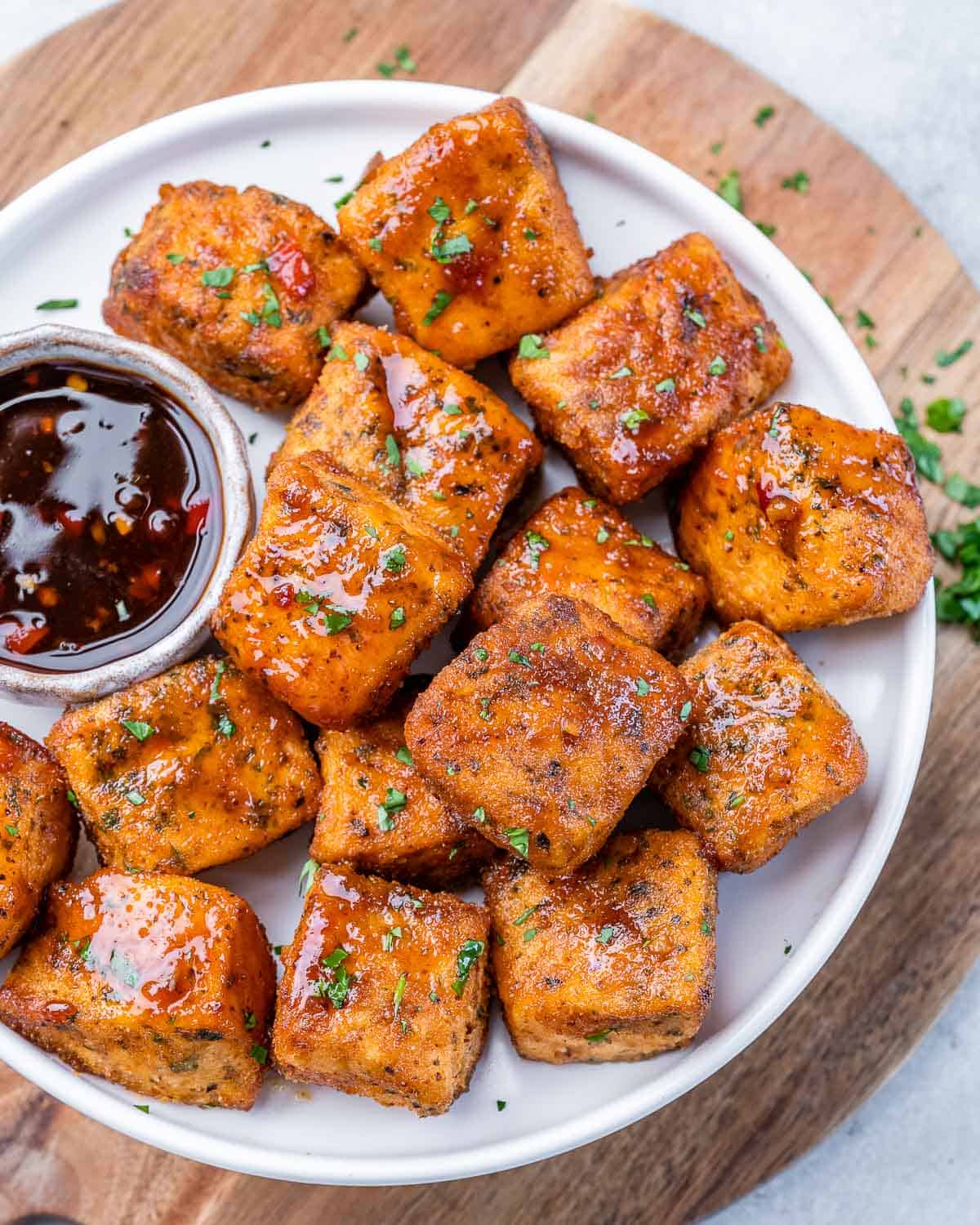 Air fryer salmon on a white plate served with sauce.