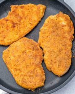 Chicken cooking in a skillet.