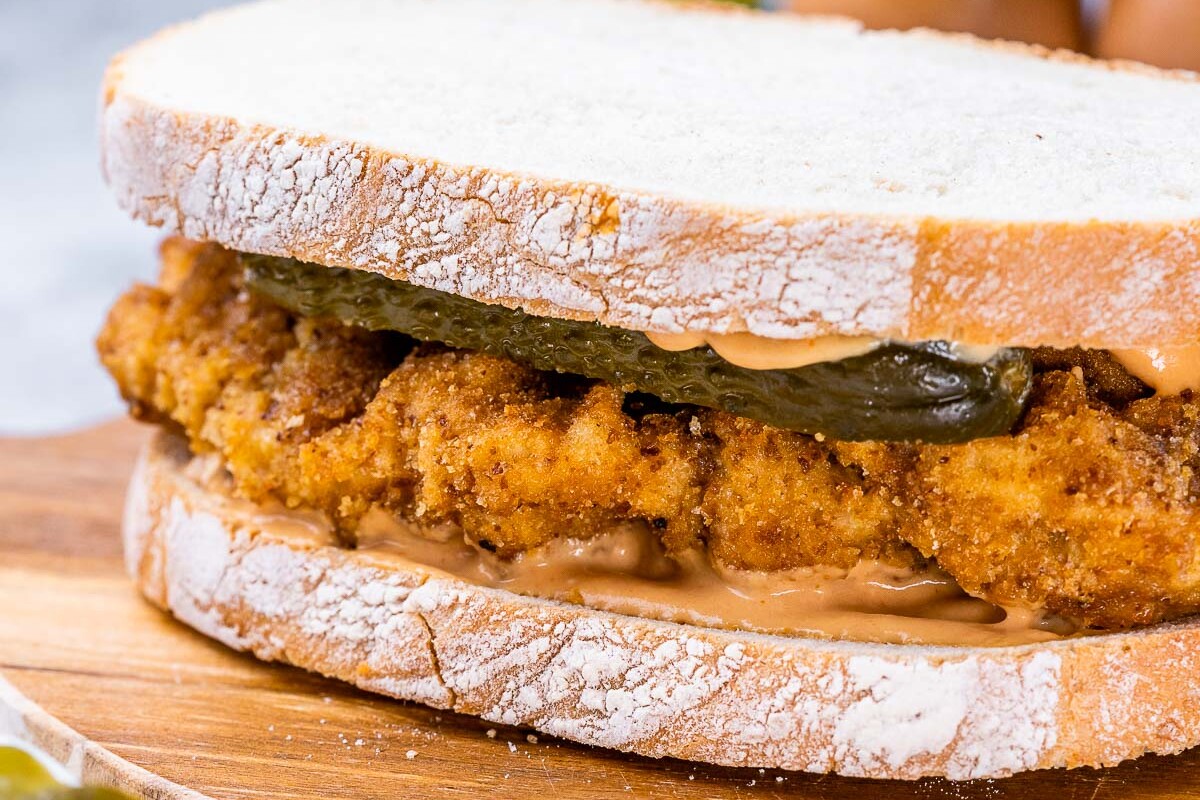Crispy chicken served on toasted bread with pickles.