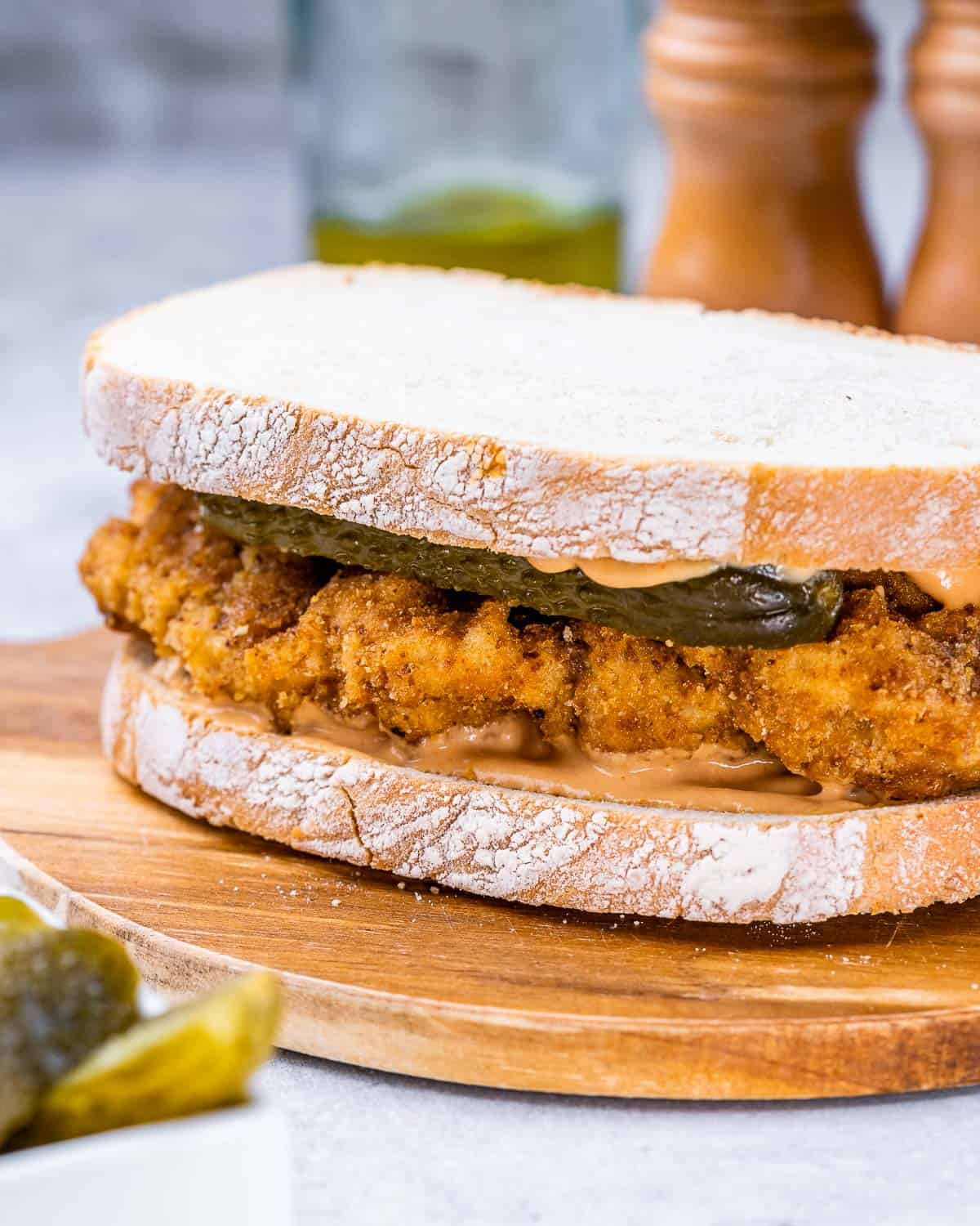 Crispy chicken served on toasted bread with pickles.