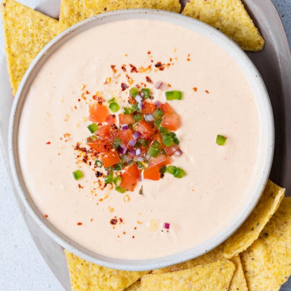 top view of queso dip made with cottage cheese in a bowl topped with pico de galo and surrounded by tortilla chips
