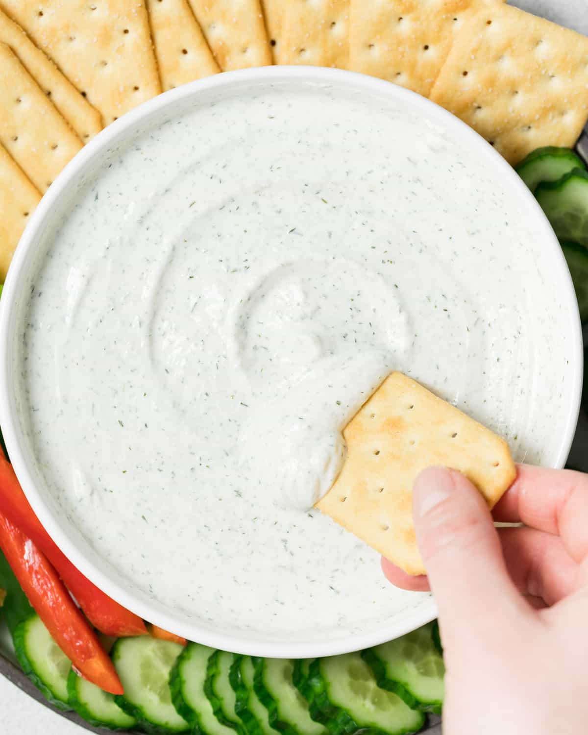 Dipping cracker into cottage cheese ranch dip.