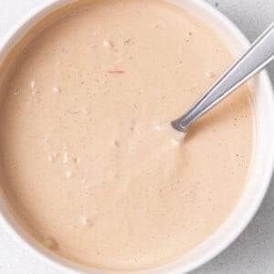 a round white bowl of in-n-out sauce with a spoon in the bowl