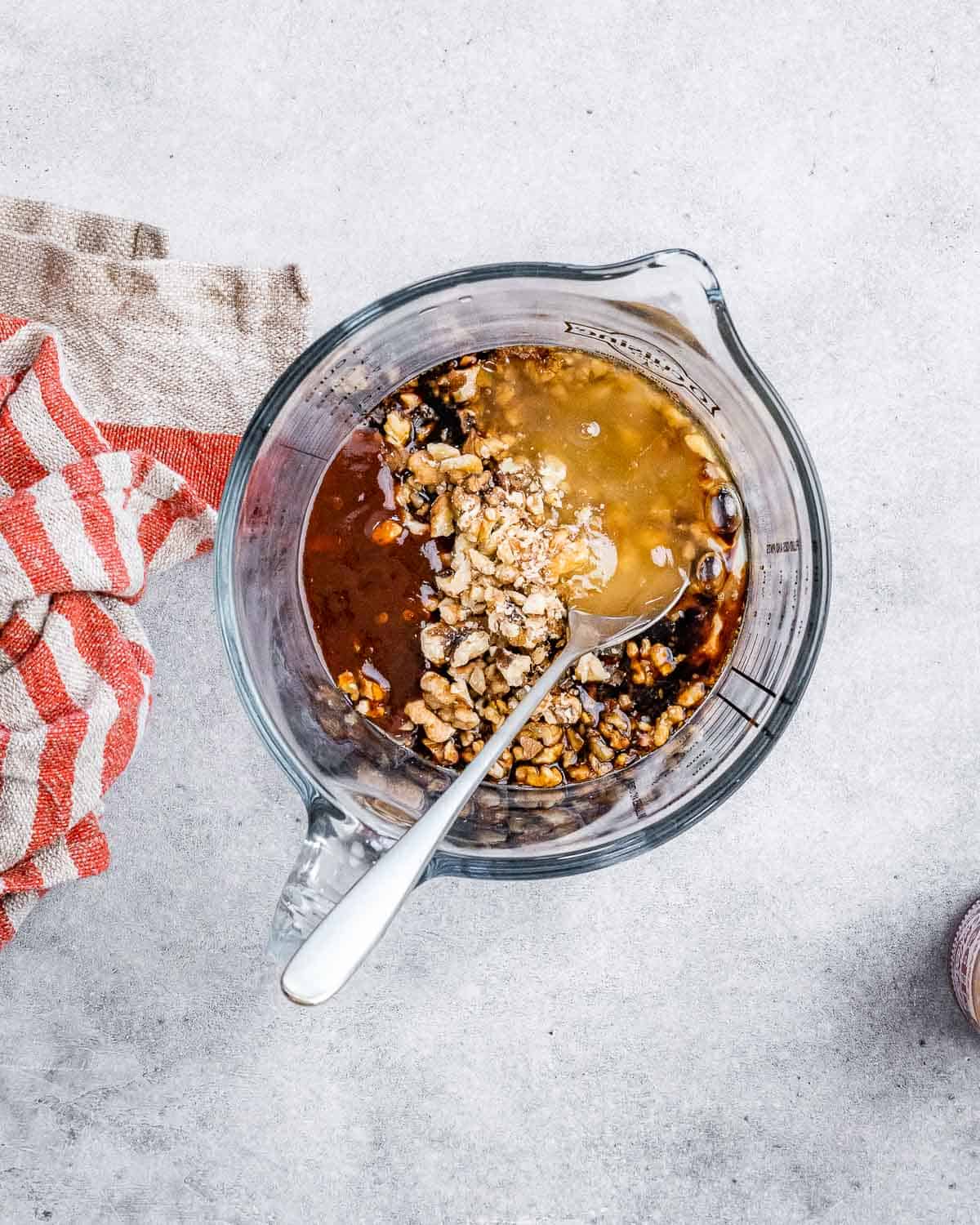 Stirring together soy sauce with honey and walnuts.