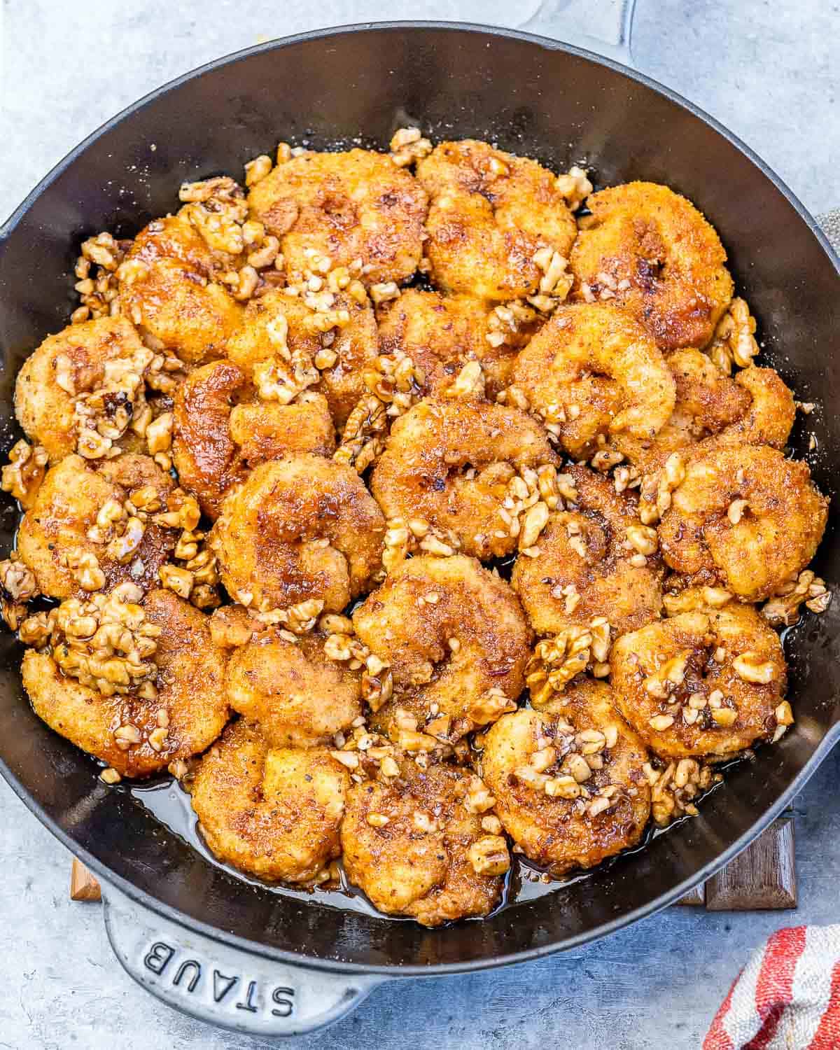 a black skillet filled with crispy honey walnut shrimp.