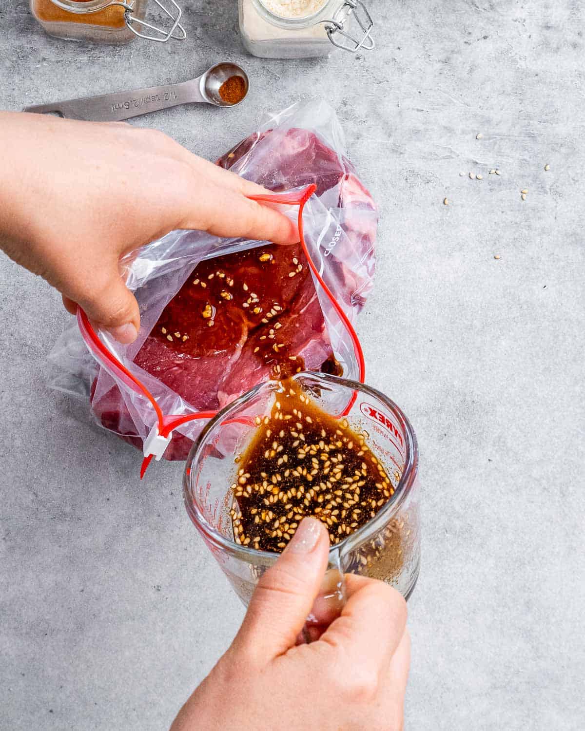 Pouring marinade into bag with steak.