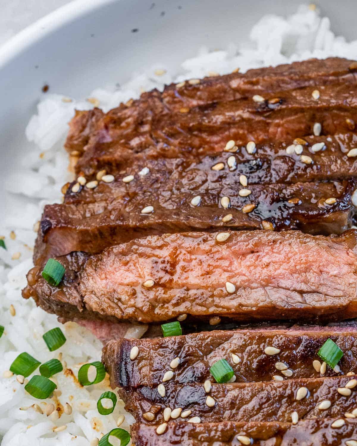 Sliced teriyaki steak topped with sliced green onion.