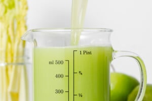 A jar with celery juice being poured into it.