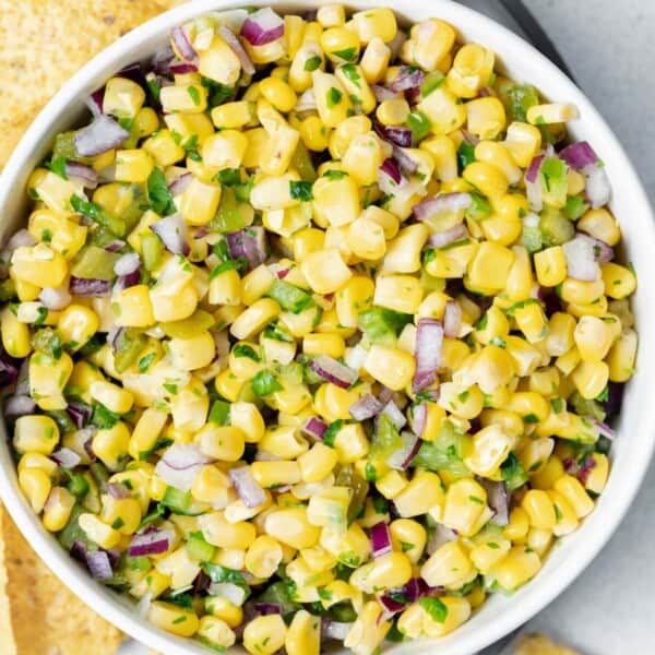 a round white bowl with copycat corn salsa.