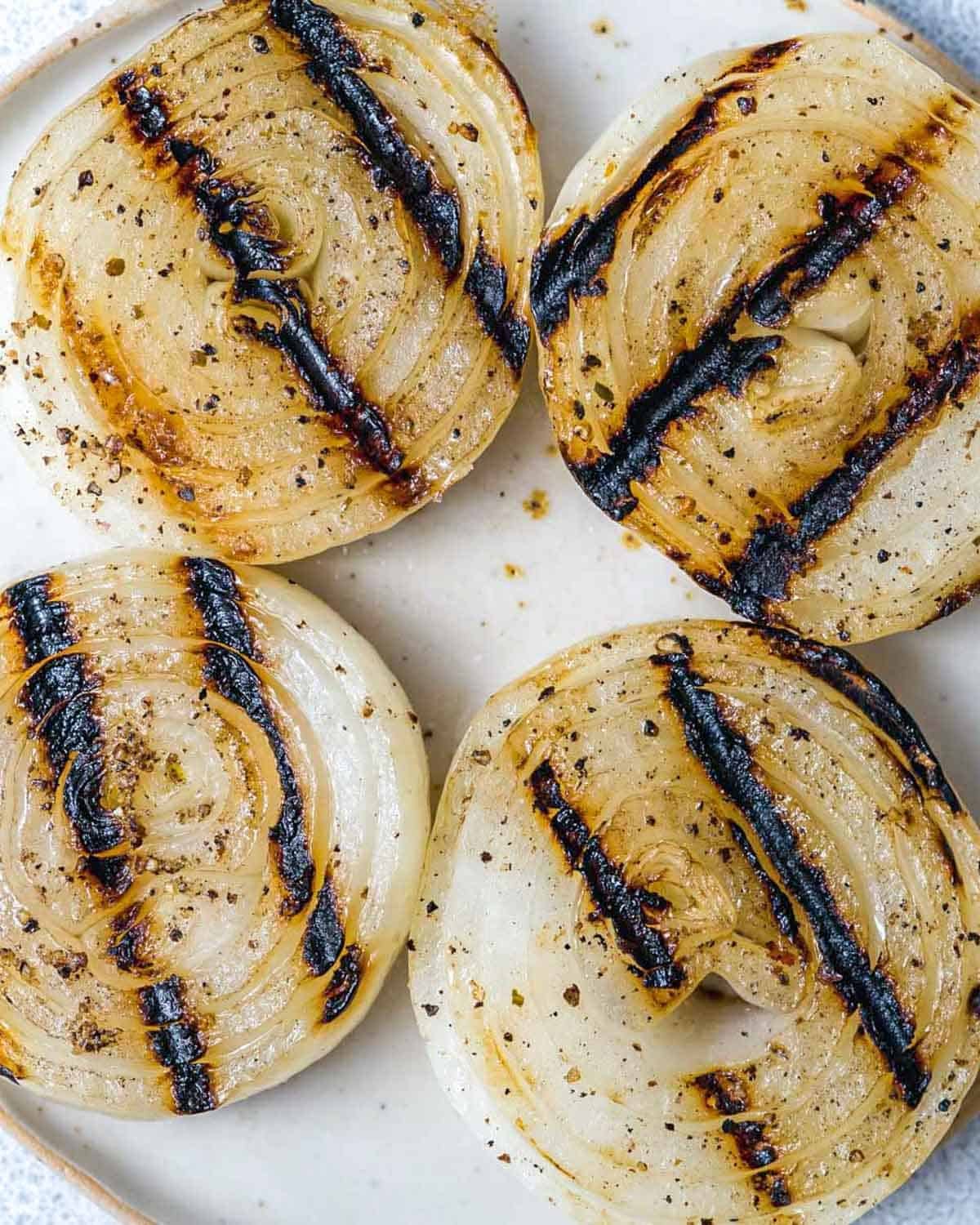 4 slices of grilled onion on a plate.