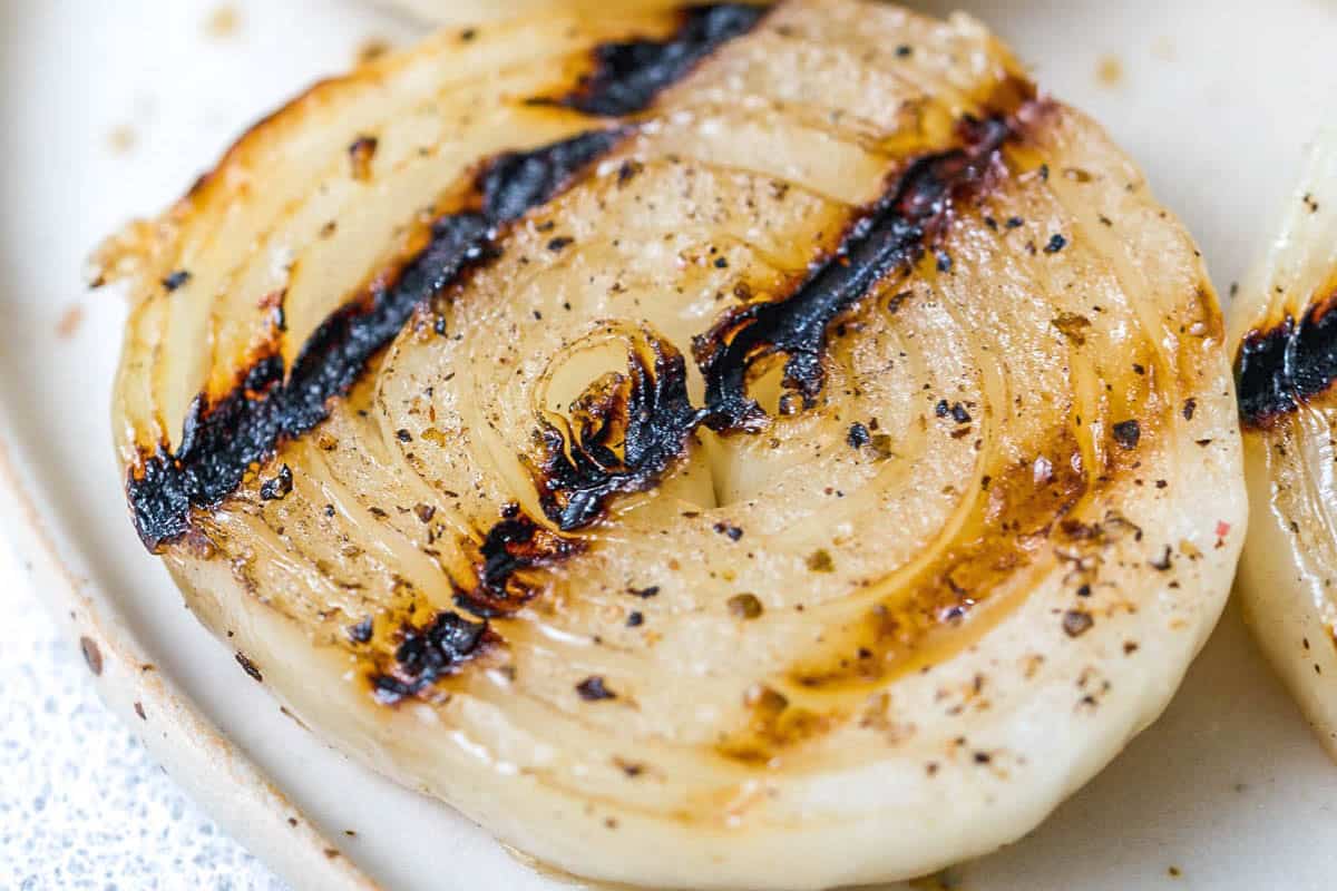 A slice of grilled onion on a plate.