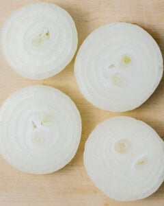 Sliced onion on a cutting board before grilling.