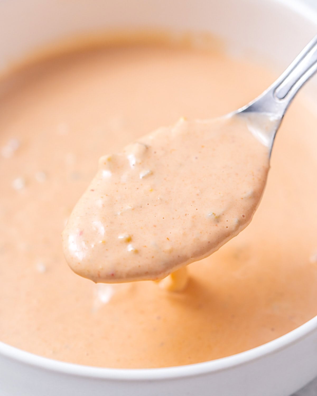 a bowl with in n out sauce and a spoon getting some sauce from bowl.