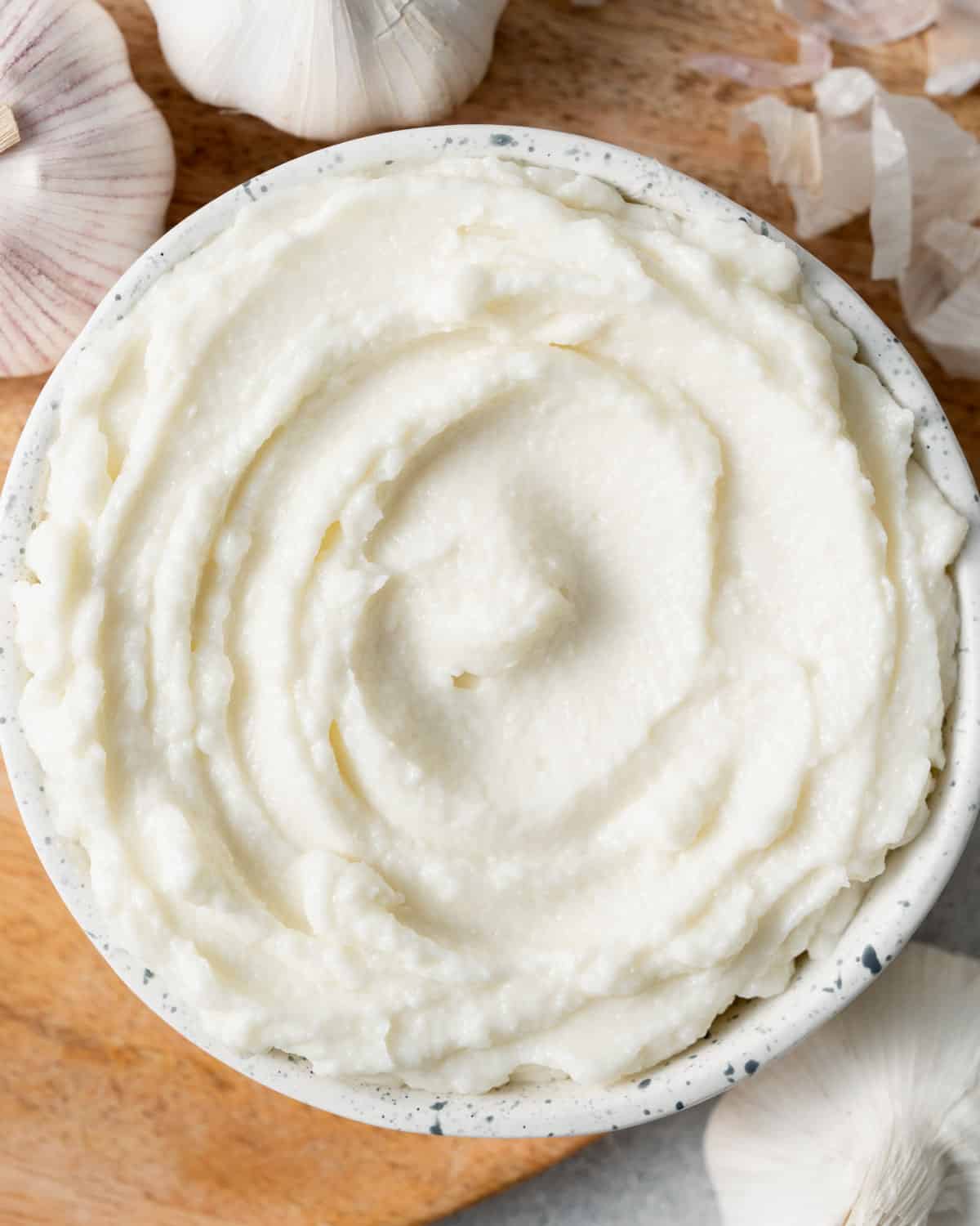 a round white bowl with garlic sauce.