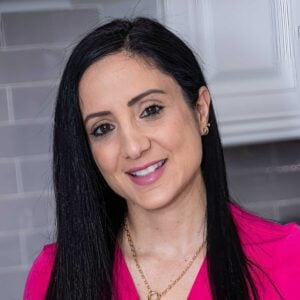 rena in pink shirt smiling into the camera