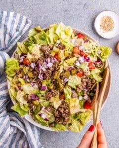 Big Mac salad in a large serving bowl near salad tongs.