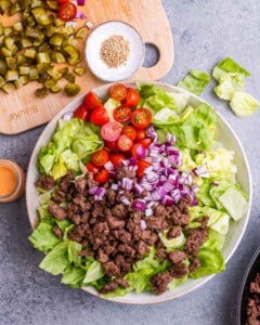 Adding ground beef with veggies in a large bowl.