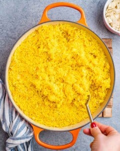 Fluffy turmeric rice in a pot after cooking, before adding garnishes.